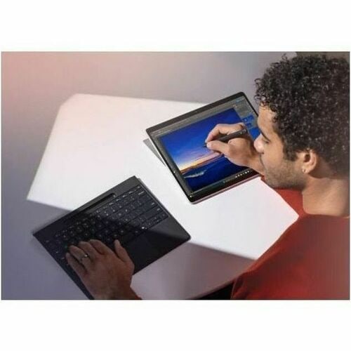 Person using a laptop with a stylus on a white surface