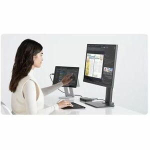 Person using a computer with dual monitors on a white background