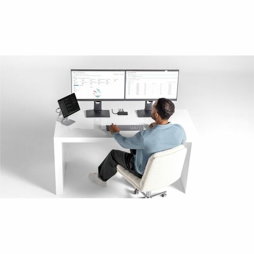 Person sitting at a modern desk with multiple computer monitors and devices.