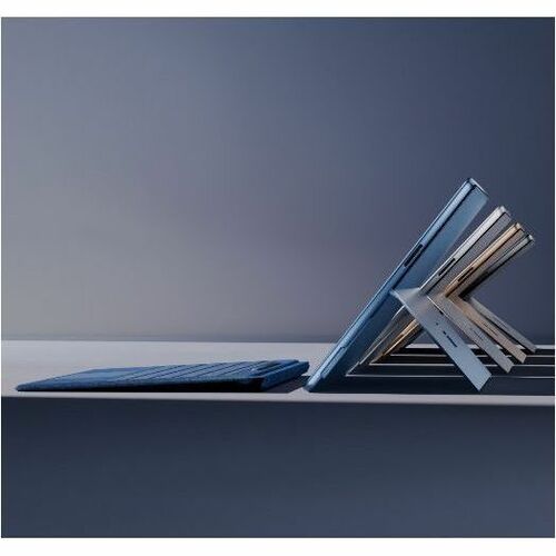 Two stacked laptop computers on a dark surface with a gradient background