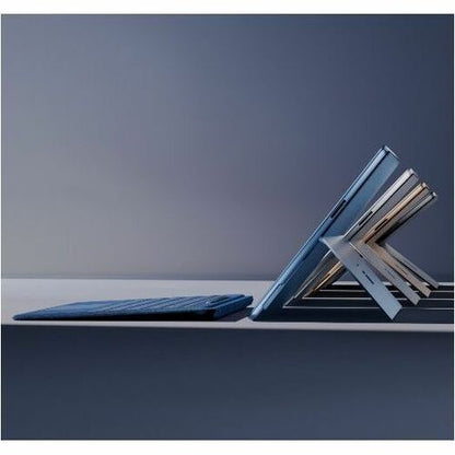 Two stacked laptop computers on a dark surface with a gradient background