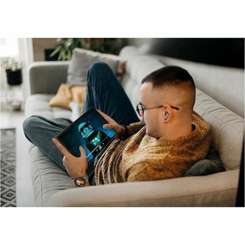 Person sitting on a couch holding a smartphone with a blurred screen